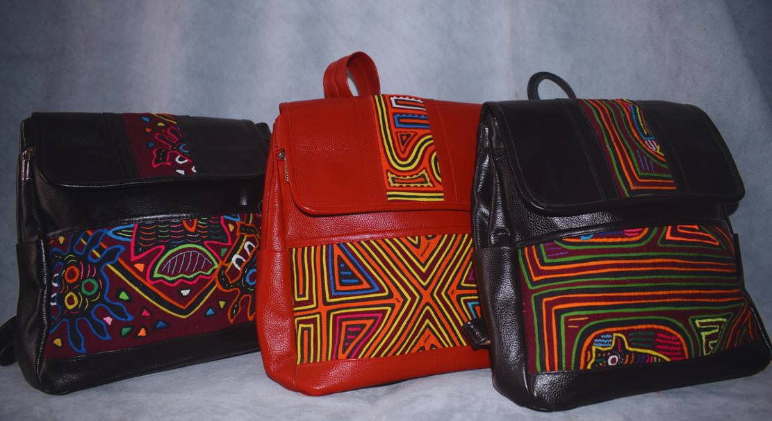 Tres bolsos de hombro coloridos con estampados en negro, rojo y multicolor, alineados uno al lado del otro.