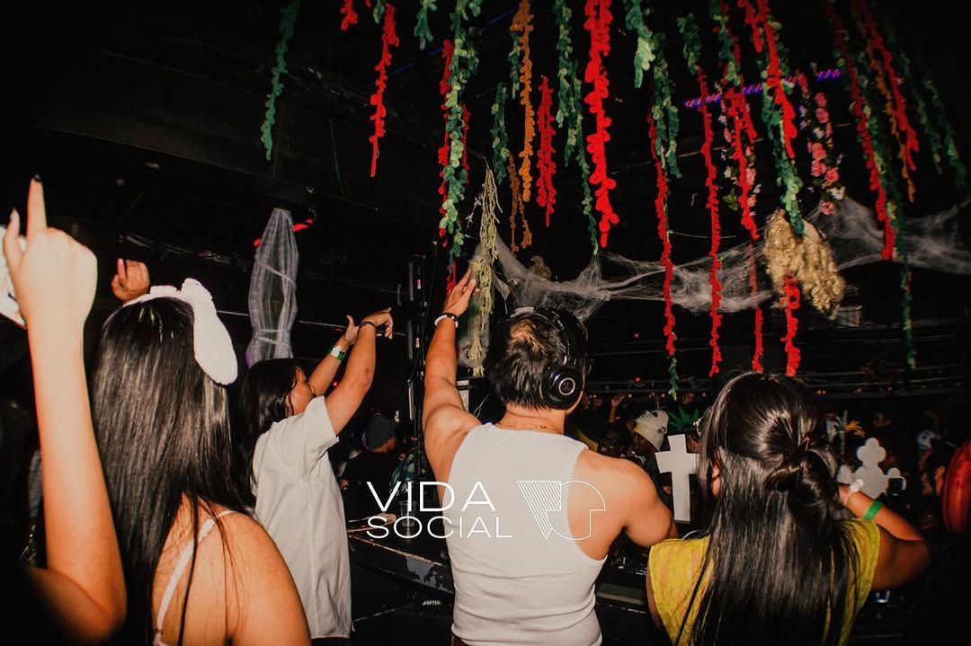 Crowd dancing under hanging red and green streamers at a nighttime party