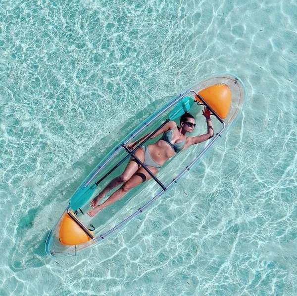 vrouw in bikini ontspannen in transparante kajak