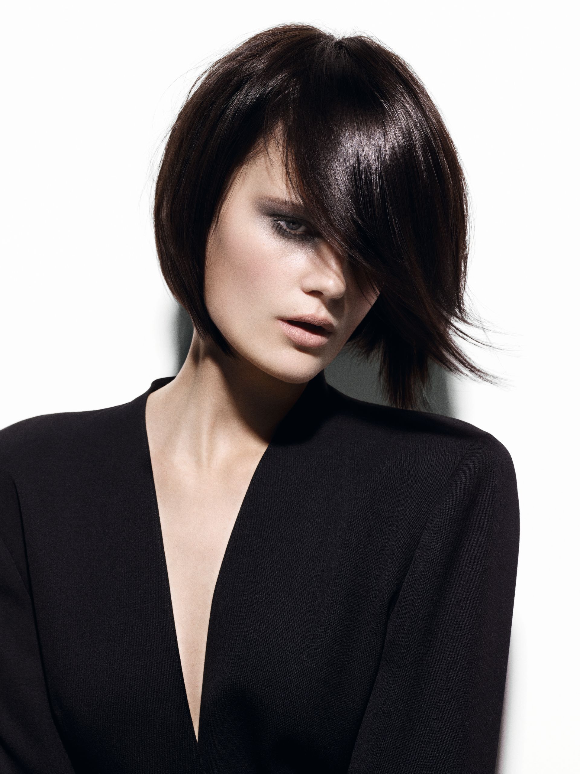 Woman with short, white hair styled with a fringe of blue, red, and black. Side profile, bare shoulders, pale skin.