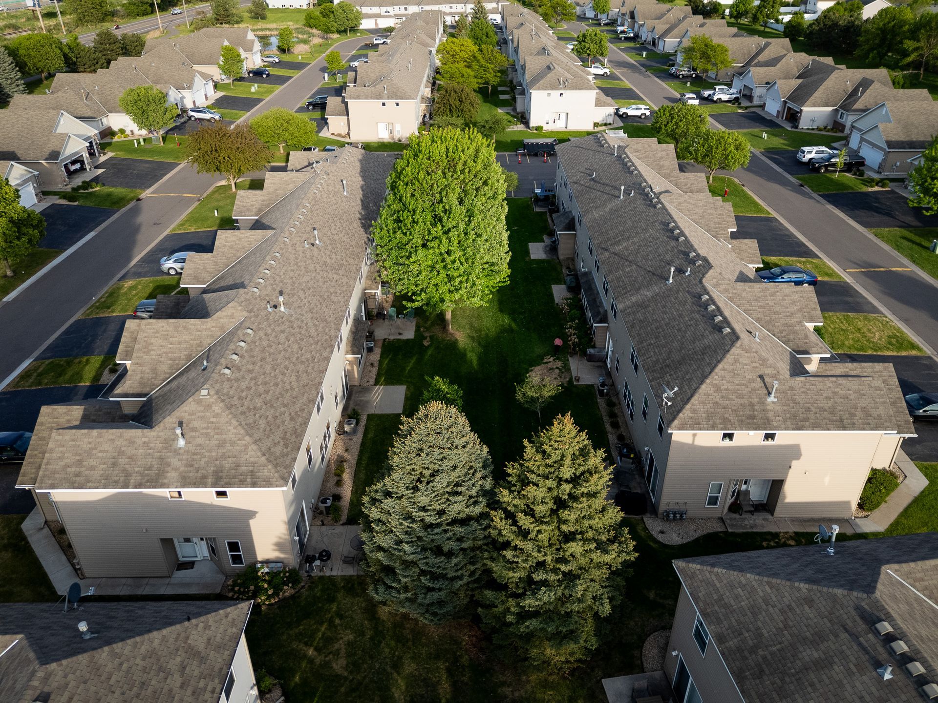 Aerial view of apartment buildings and a tree-lined courtyard in a residential complex