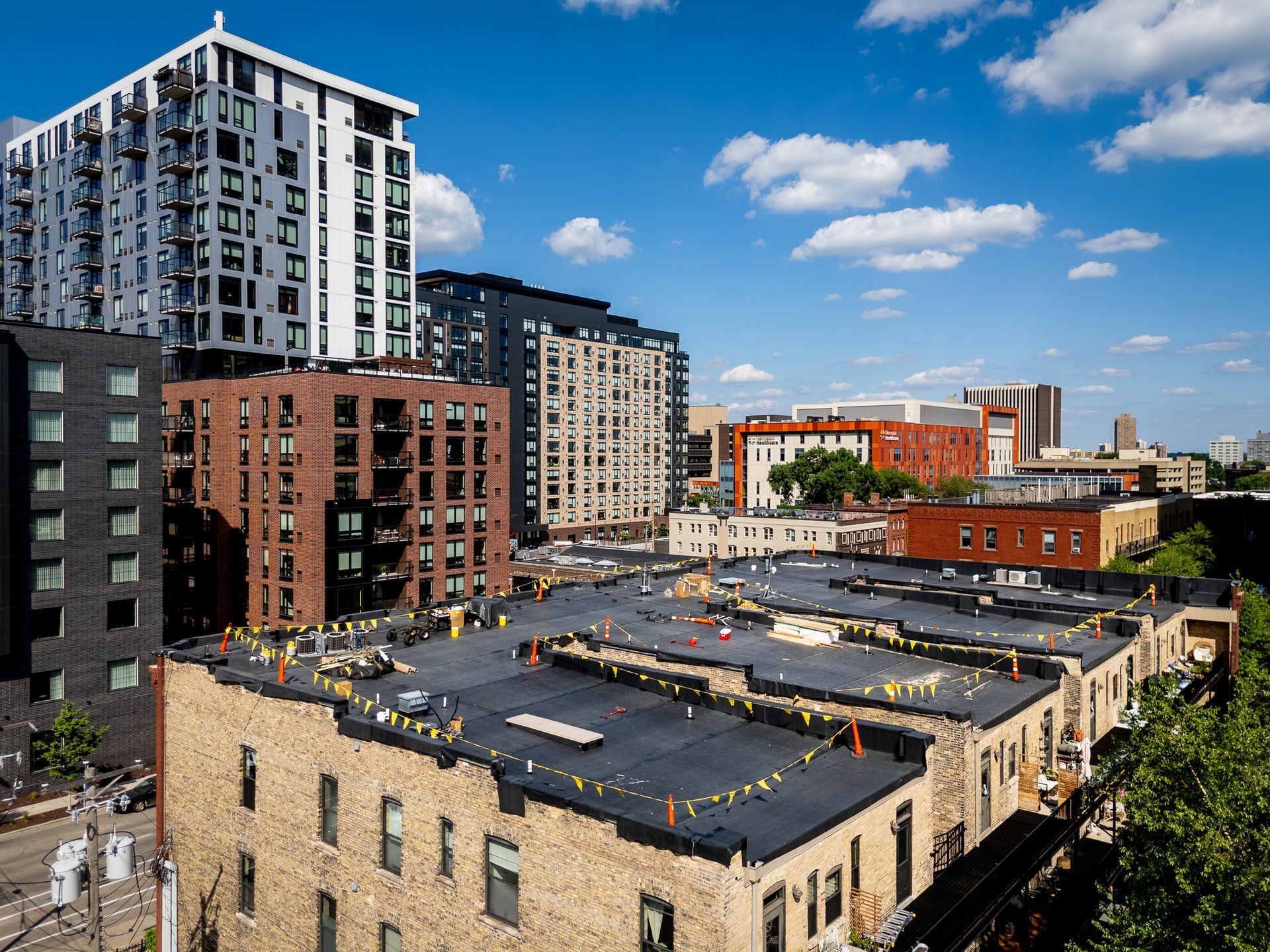 City skyline with modern apartment buildings and a rooftop parking lot under a blue sky