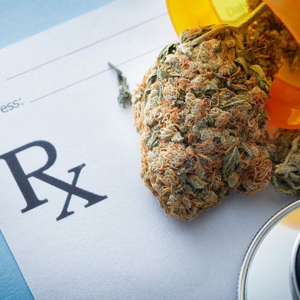 Cannabis bud and prescription pill bottle on an Rx form