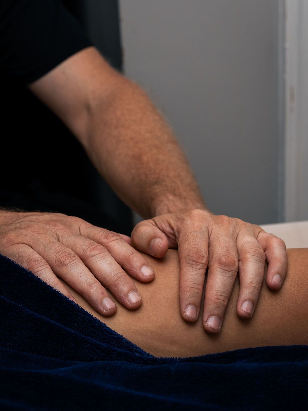Hands resting on a person’s knee during a massage.