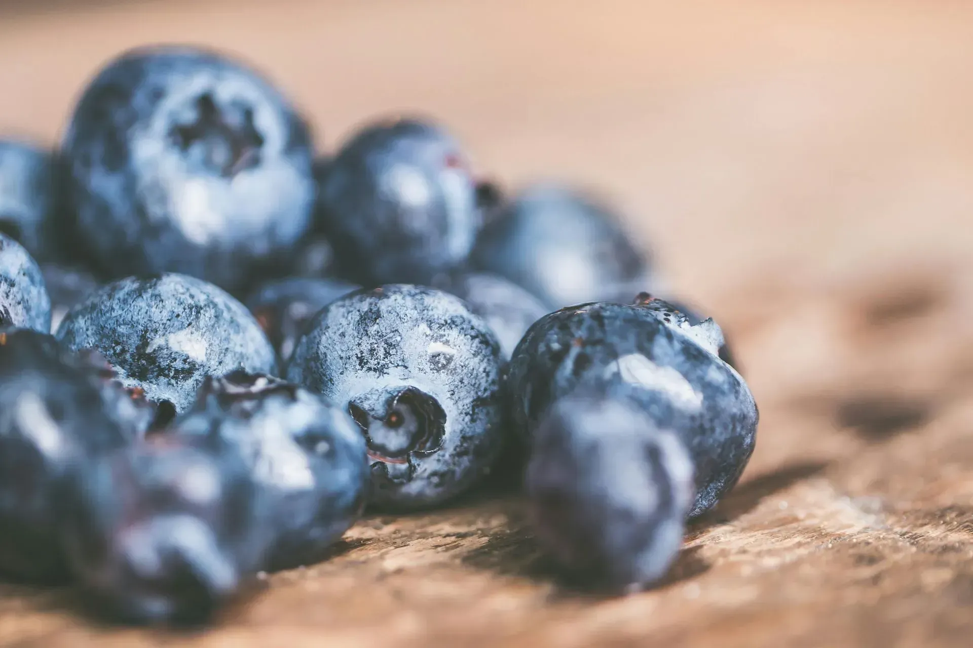 Close-up of ripe blueberries with a dusty bloom on a wooden surface