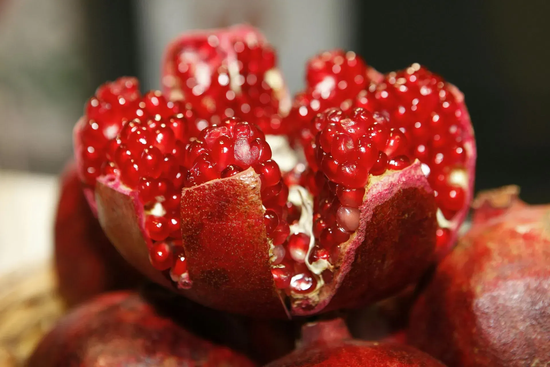 Close-up of a split pomegranate with bright red seeds exposed