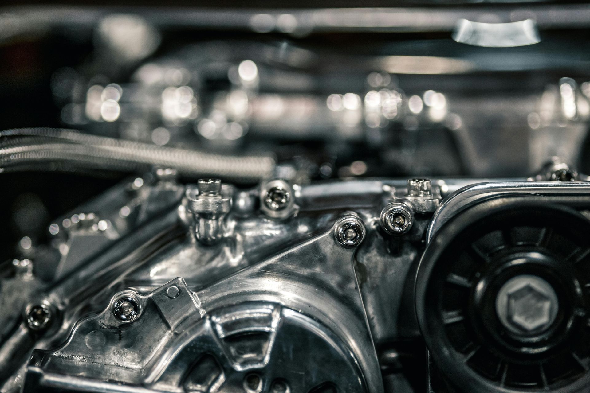 Close-up of a shiny car engine with chrome components and belts under the hood