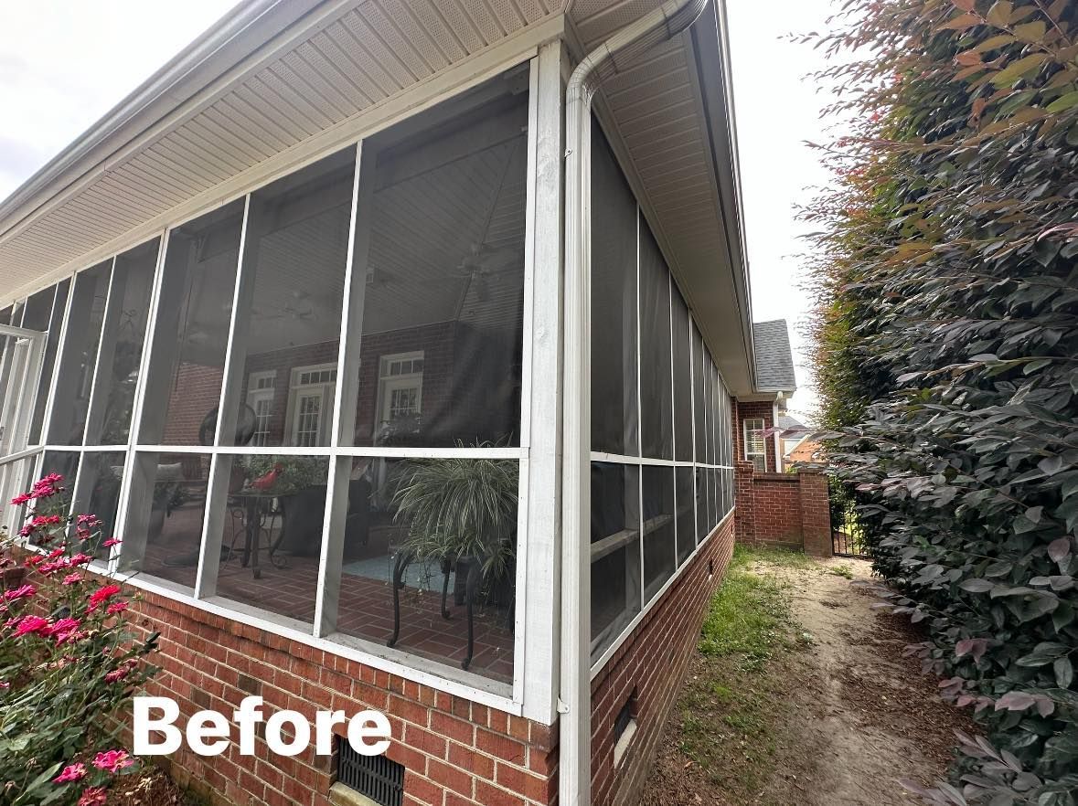 Before view of a screened porch beside a brick house and garden path