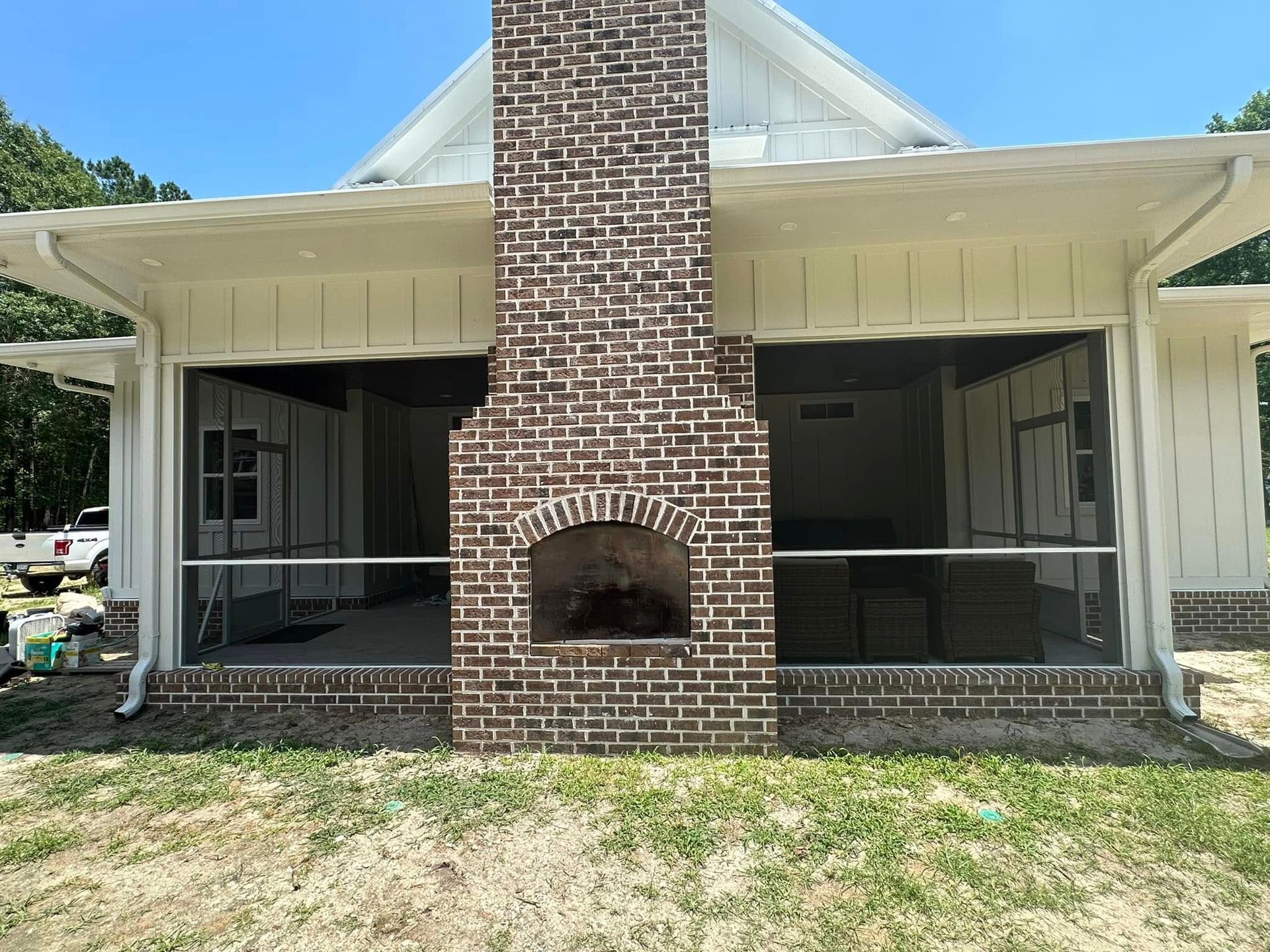 Front view of a house with a central brick chimney and a covered porch