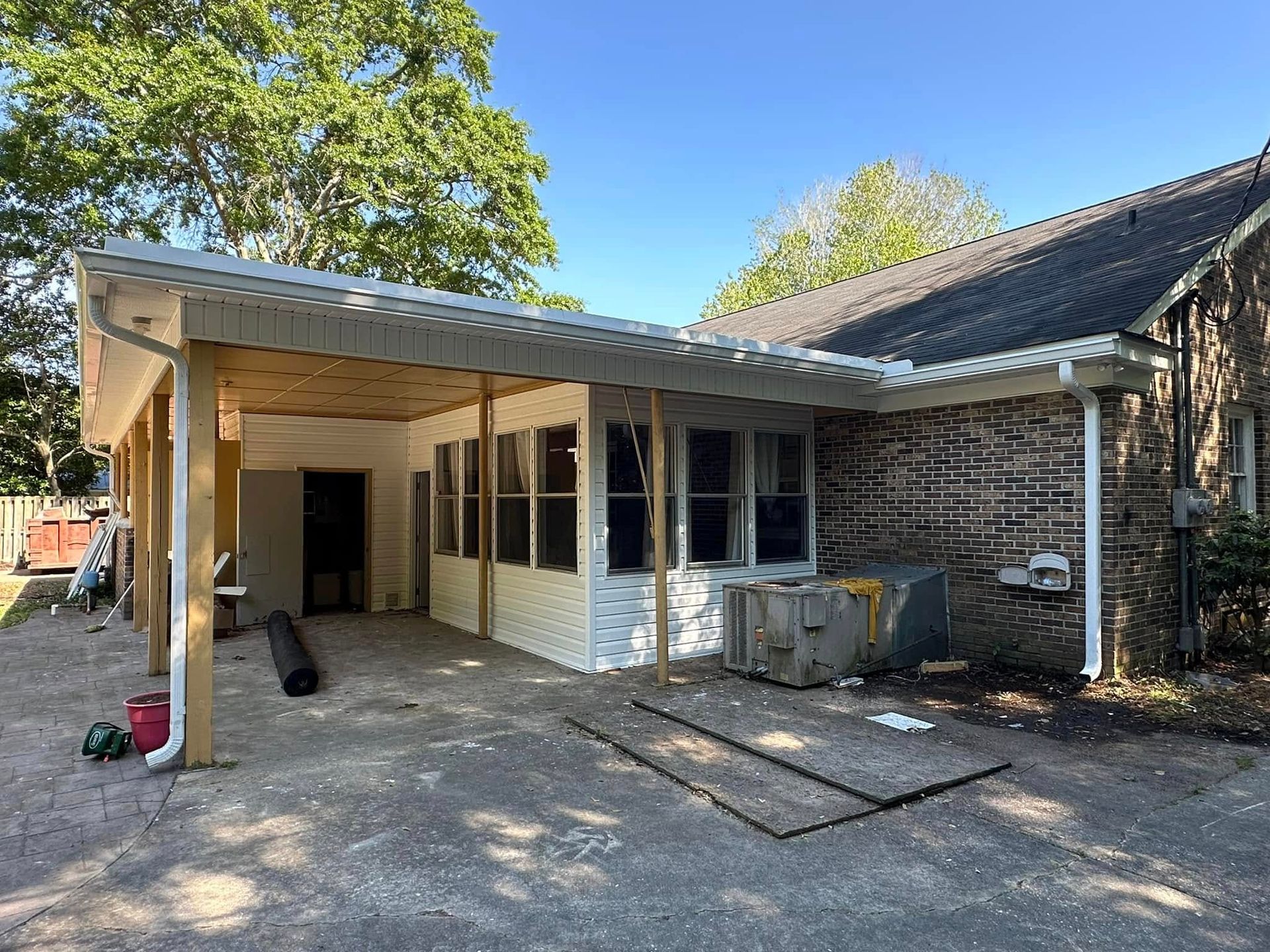 Brick house with a newly built wooden carport and gravel driveway in front