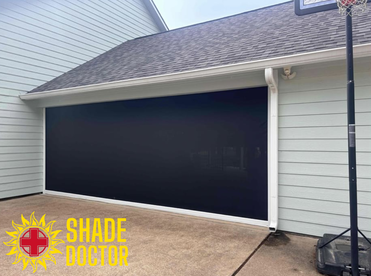 Black outdoor shade screen covering a patio opening beside a white house and basketball hoop
