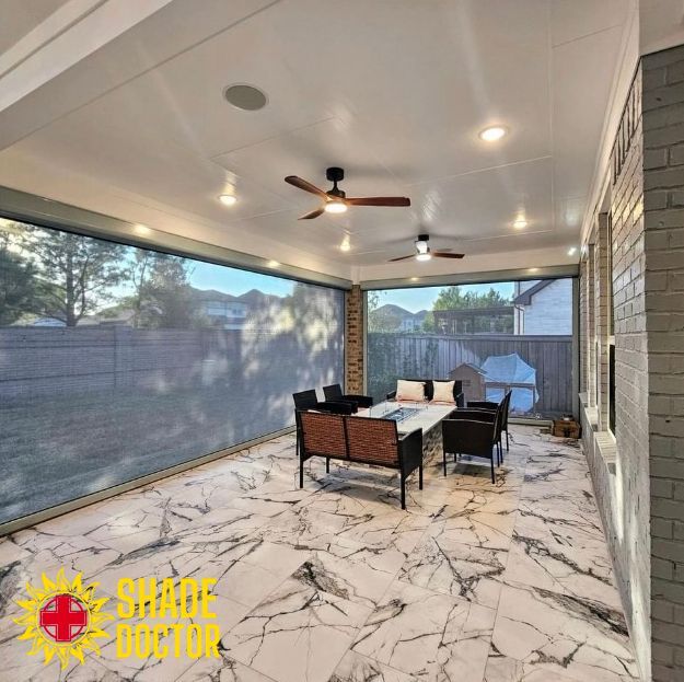 Covered patio with marble-look tile, ceiling fan, outdoor seating, and screened walls overlooking a yard