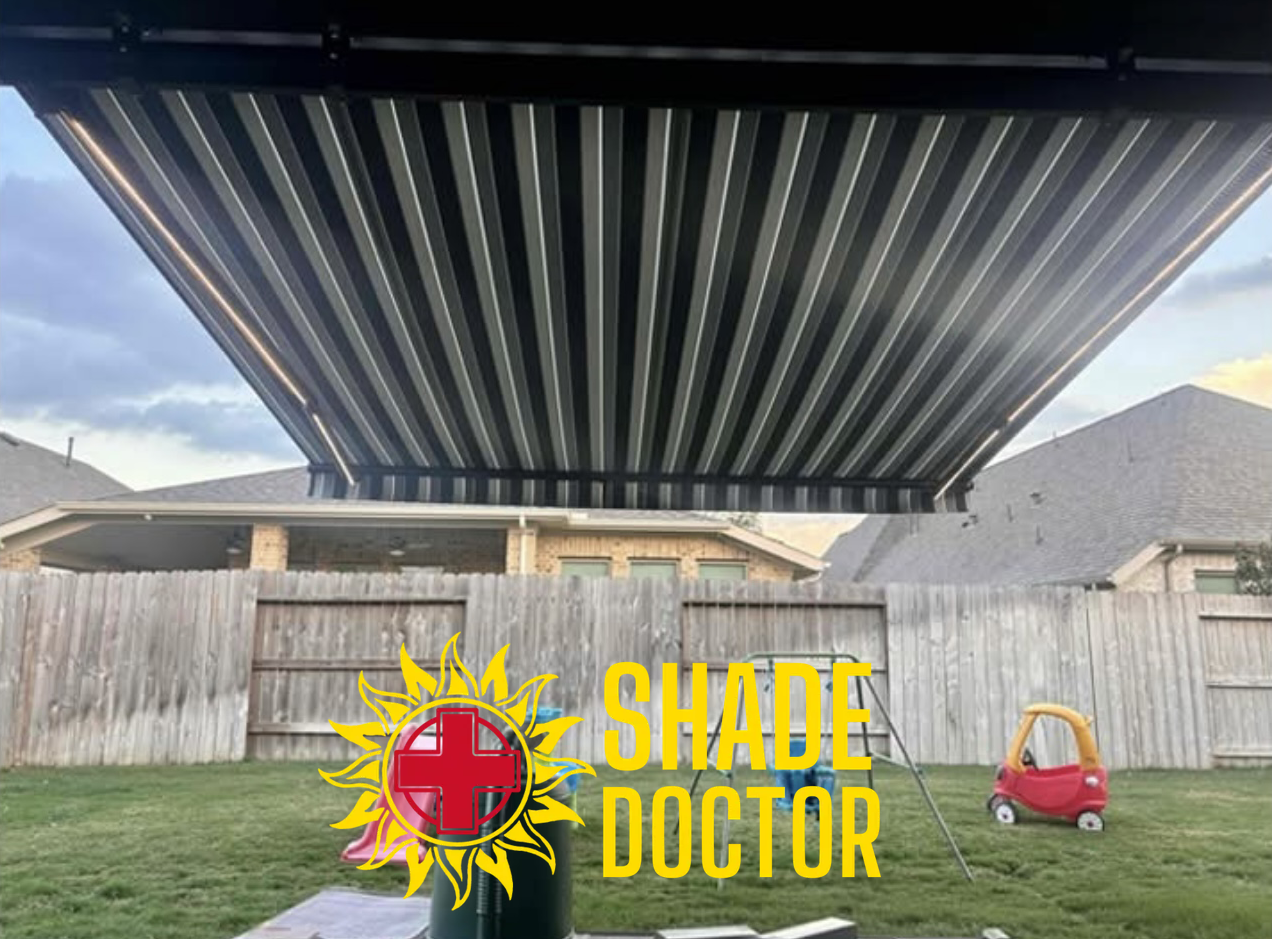 Black retractable pergola shade over a backyard patio with a house and lawn