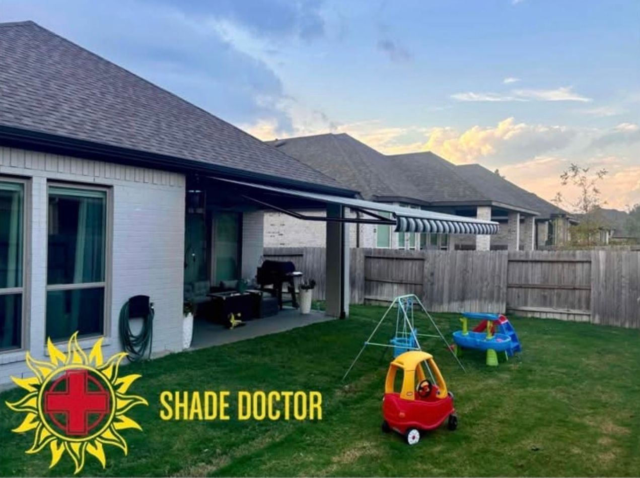 Backyard patio with lawn, children's toys, and a fenced yard beside a house at sunset