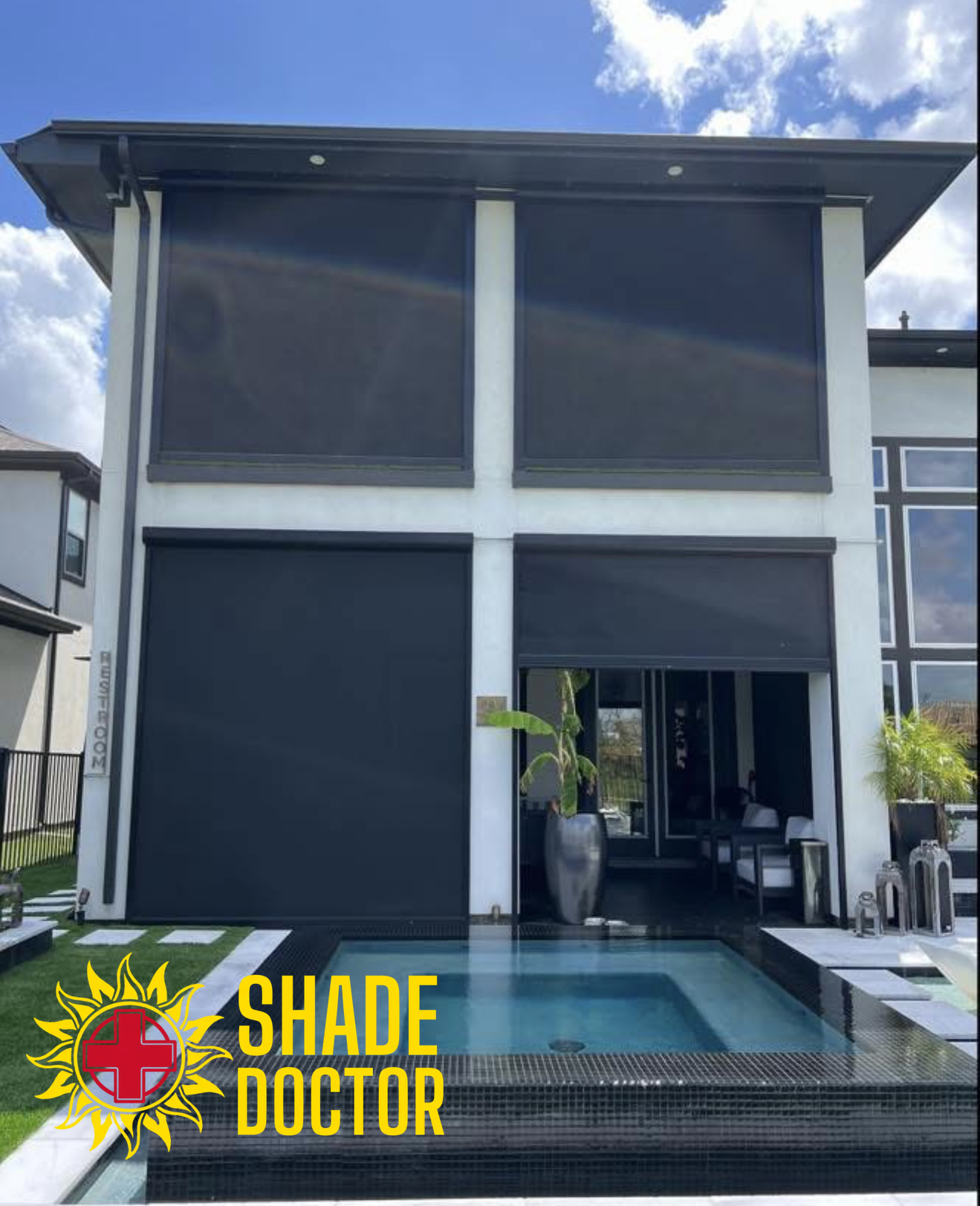 Modern house with large retractable shade screens over a poolside patio, showing a sunlit exterior.