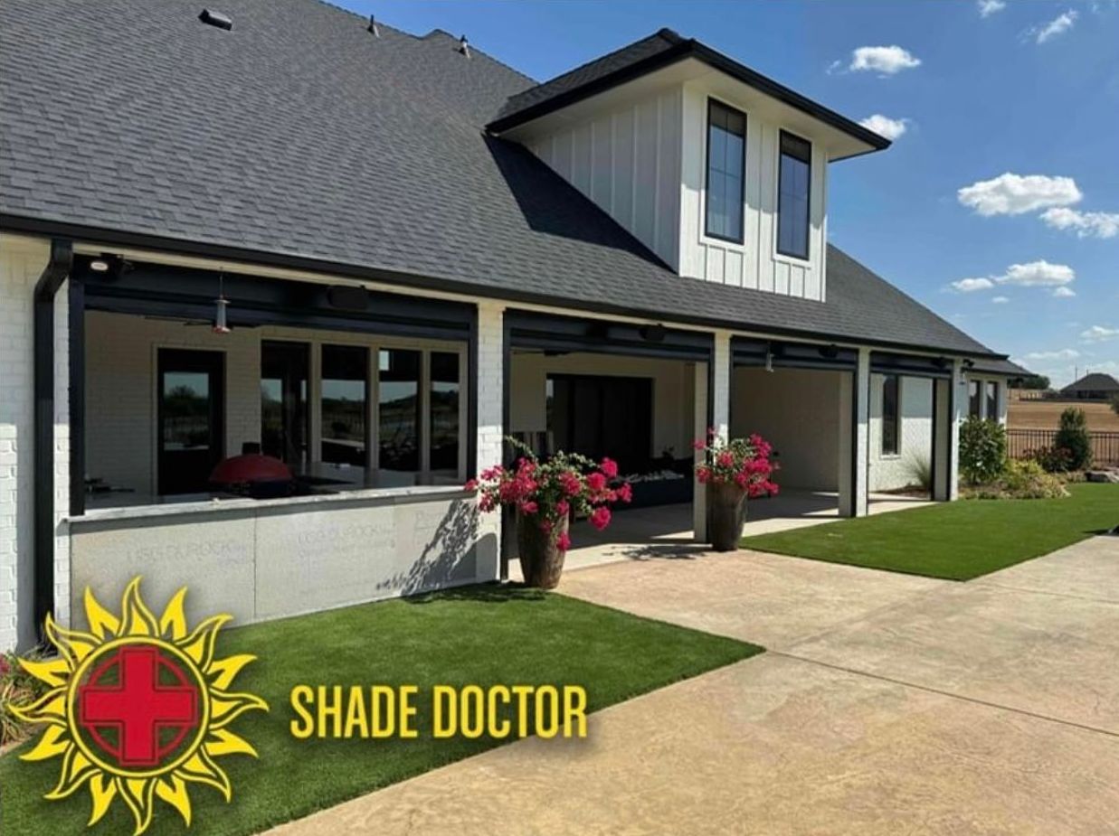 Modern house exterior with gray roof, white walls, flower planters, and concrete driveway; Shade Doctor logo in corner