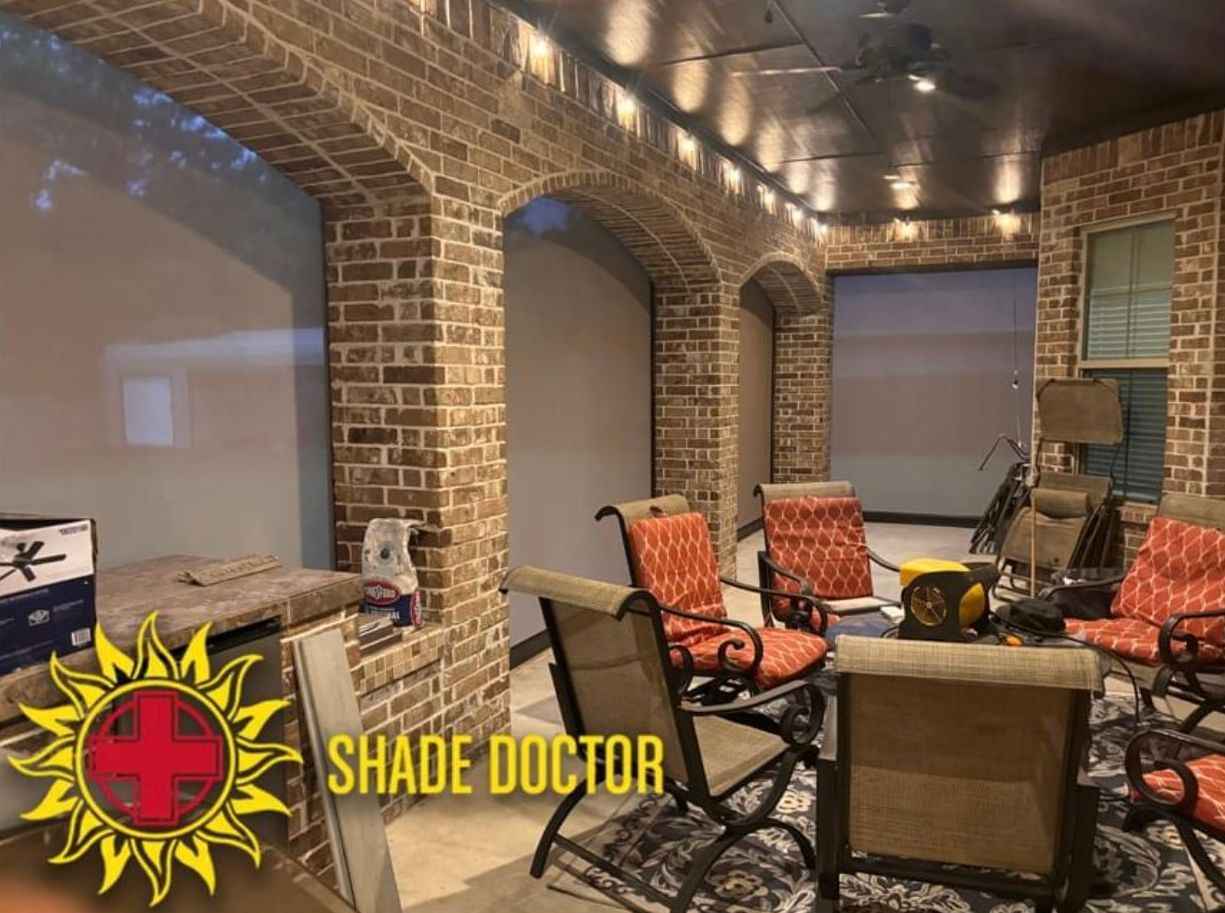 Brick patio with cushioned chairs, table, and string lights under a covered ceiling.