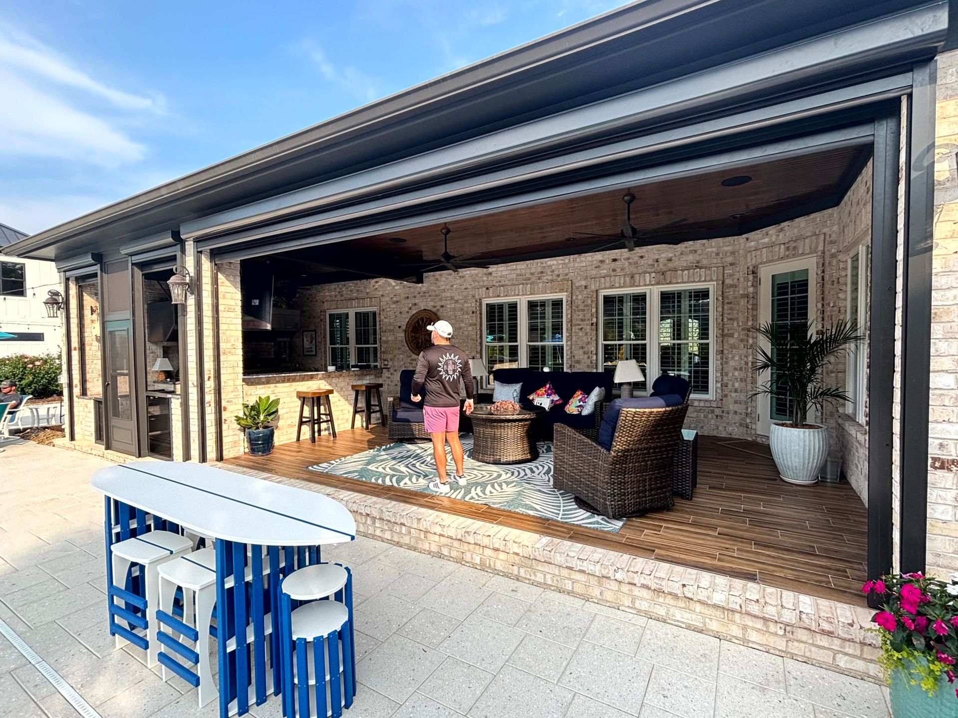 Covered patio with wicker seating, windows, and a blue-and-white table in the foreground