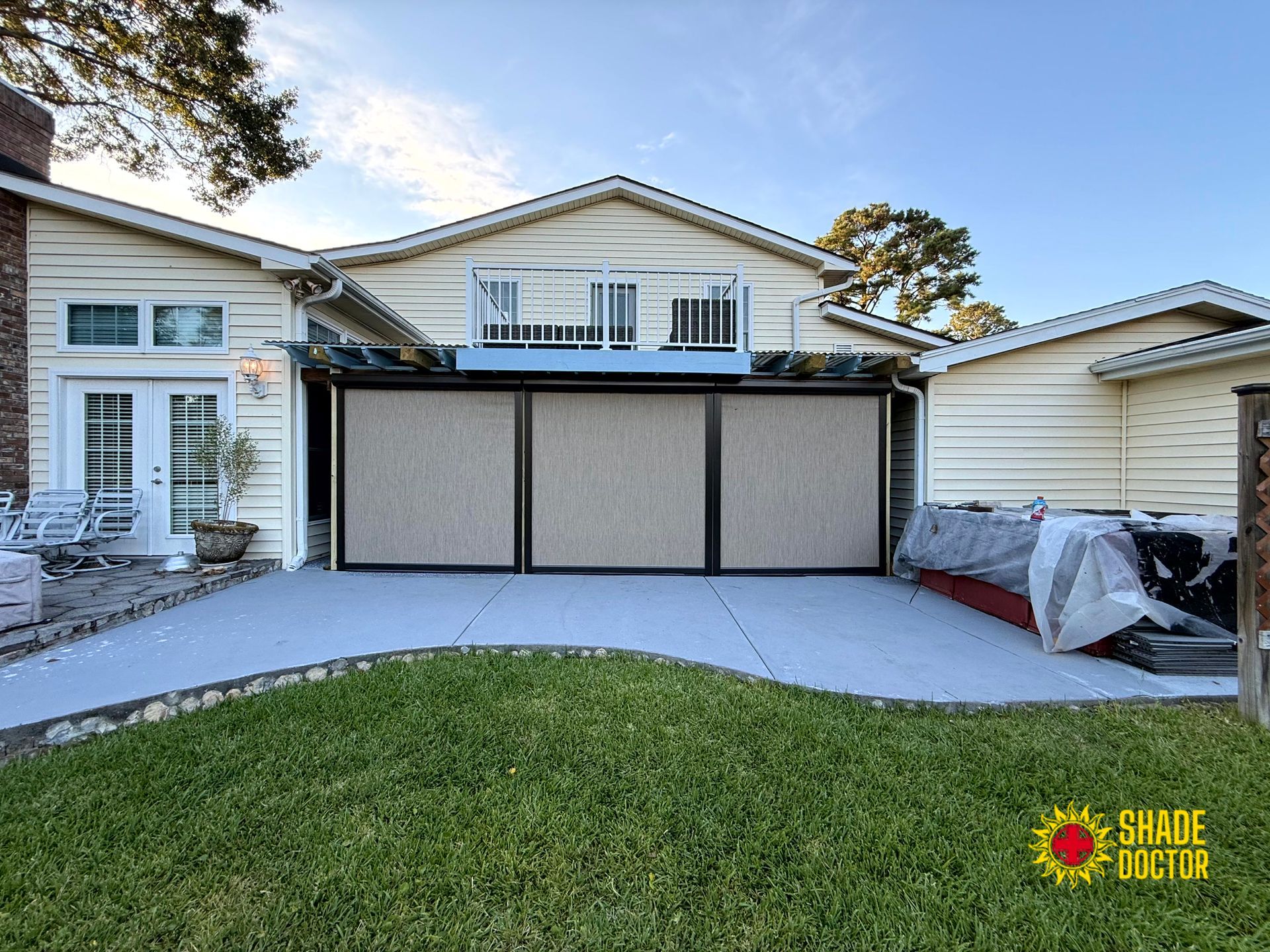 House exterior with a two-car garage, concrete driveway, and green lawn under a sunny sky