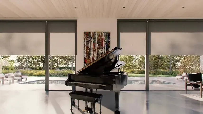 Grand piano in a modern living room with floor-to-ceiling windows overlooking a patio and greenery