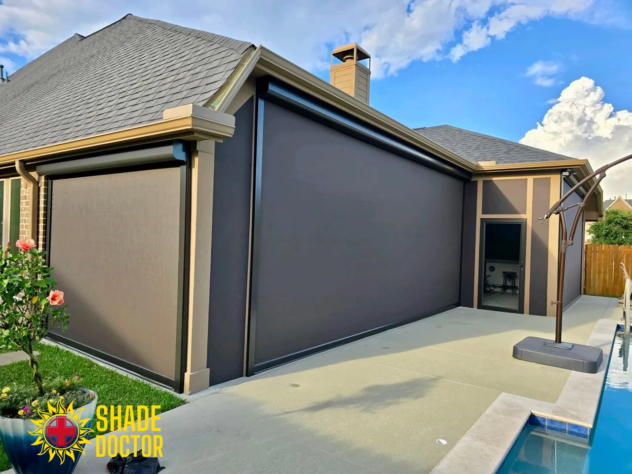 Modern house exterior with gray roller shades and a backyard pool under a blue sky