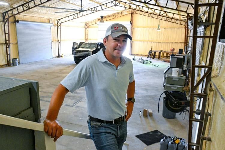 A man in a hat is standing in a garage.