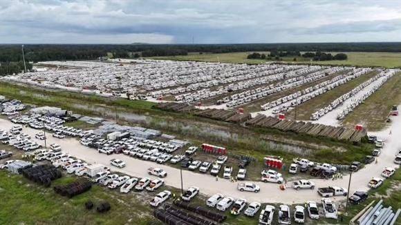 An aerial view of a large parking lot filled with lots of cars.