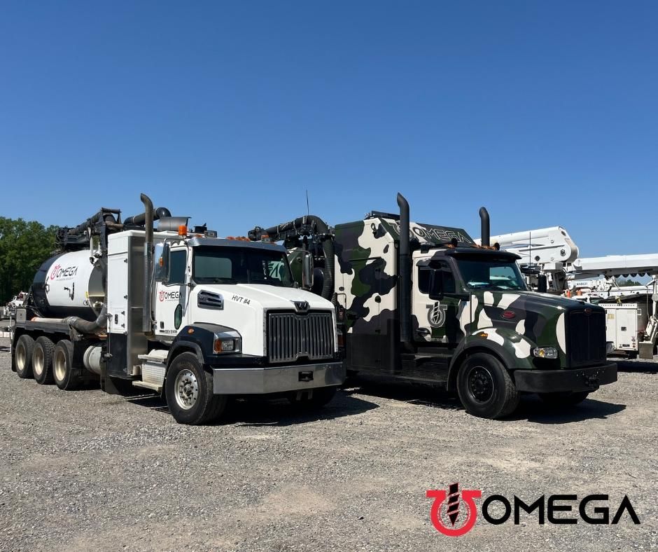 Two trucks are parked next to each other in a gravel lot.