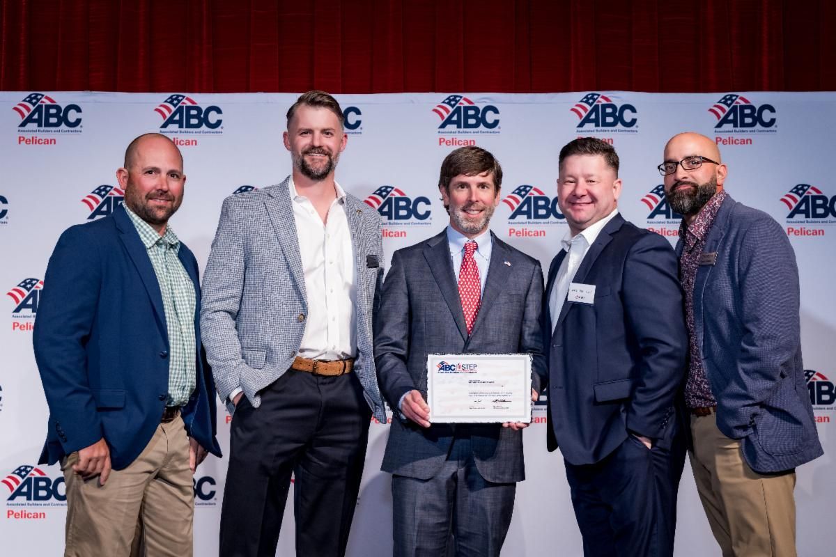 A group of men in suits are standing next to each other holding a certificate.