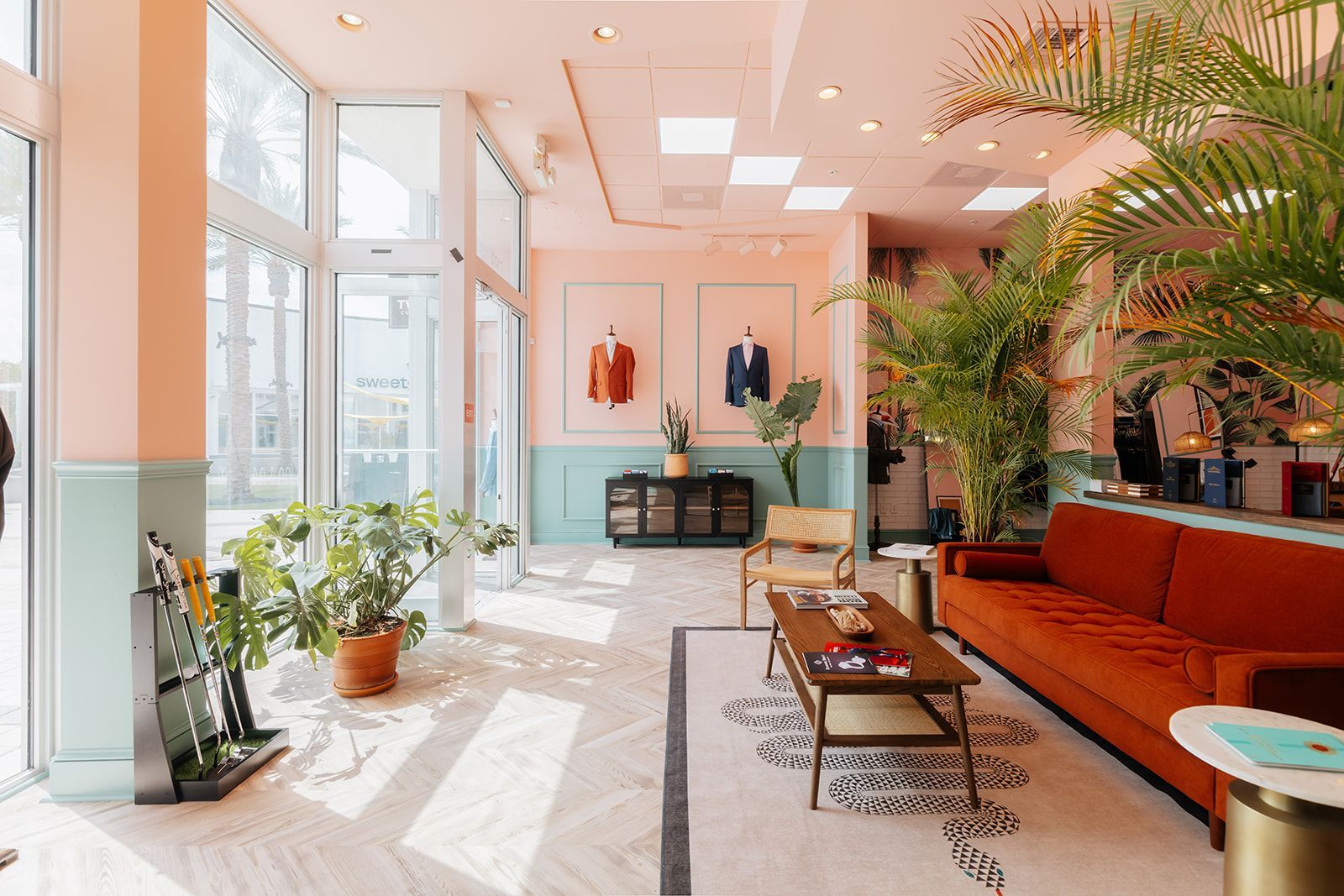 Stylish clothing store interior with colorful walls, plants, and seating area.