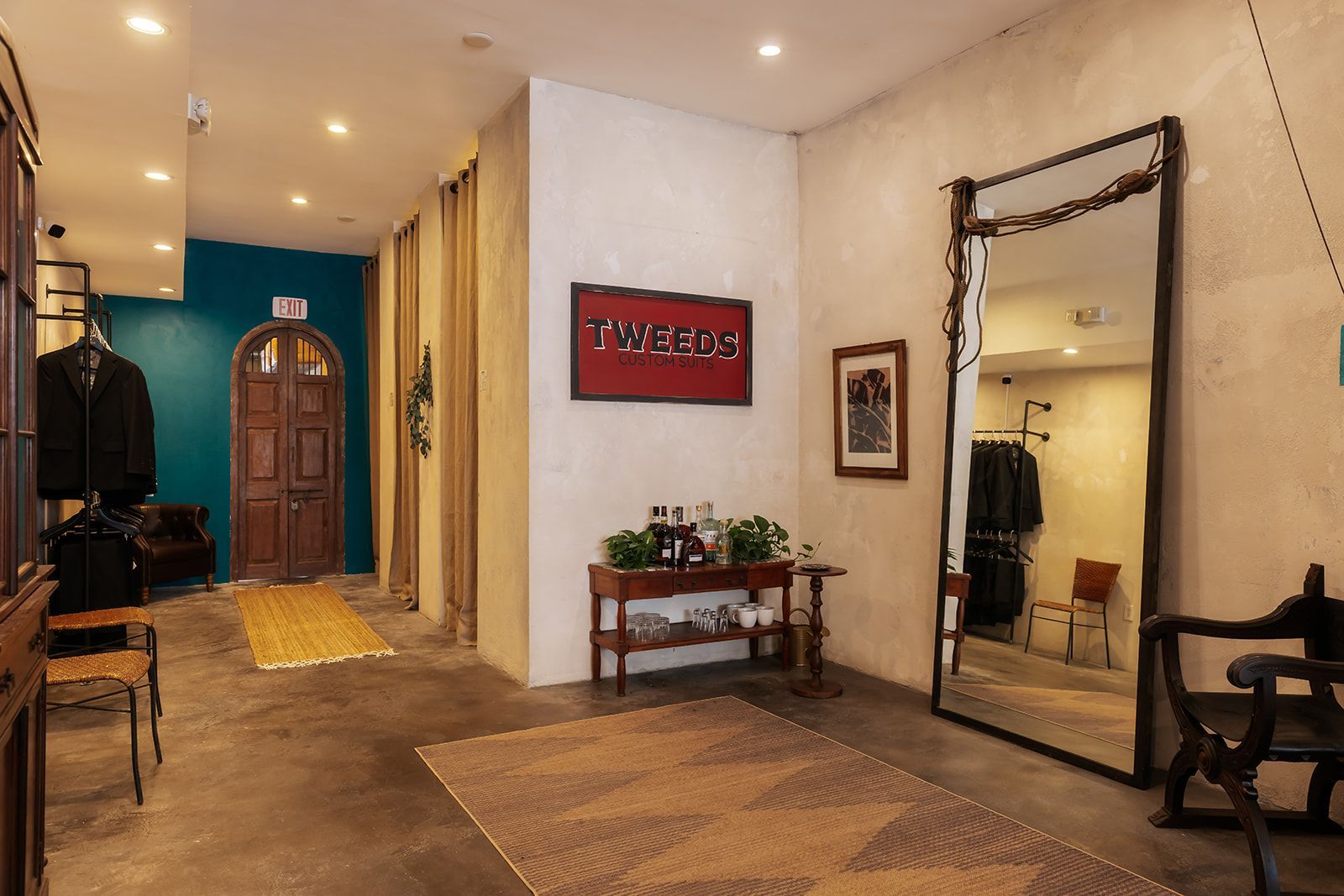 Hallway with a large mirror, coats, and a wooden door.