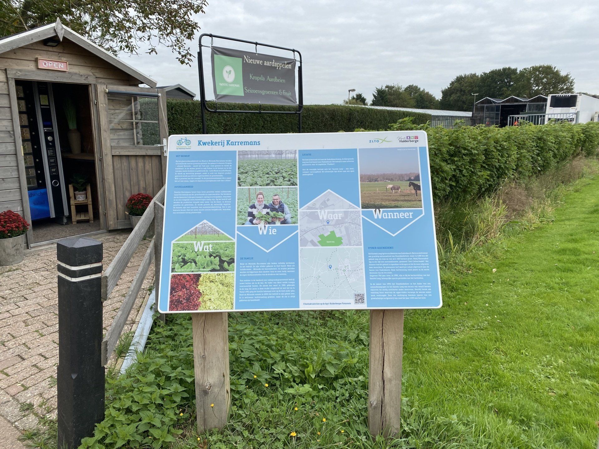 Er staat een bord in het gras voor een schuurtje.