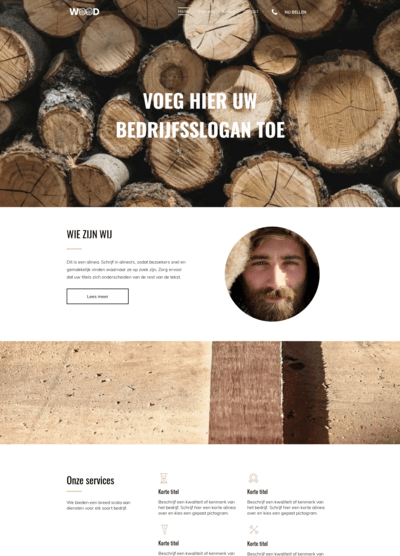 Een man met een baard staat voor een stapel boomstammen.