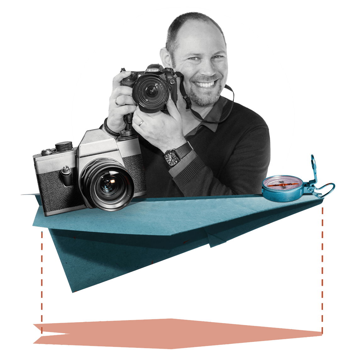 Een lachend persoon houdt een camera vast terwijl hij op een groot blauw papieren vliegtuig zit, naast een kompas.