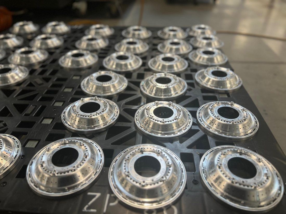 Batch of turned cups on a fixture plate