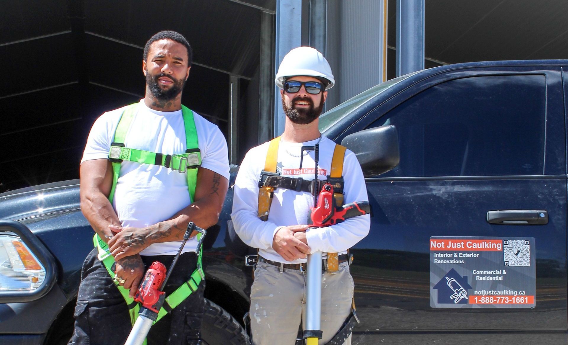 Two men are standing next to each other in front of a truck.