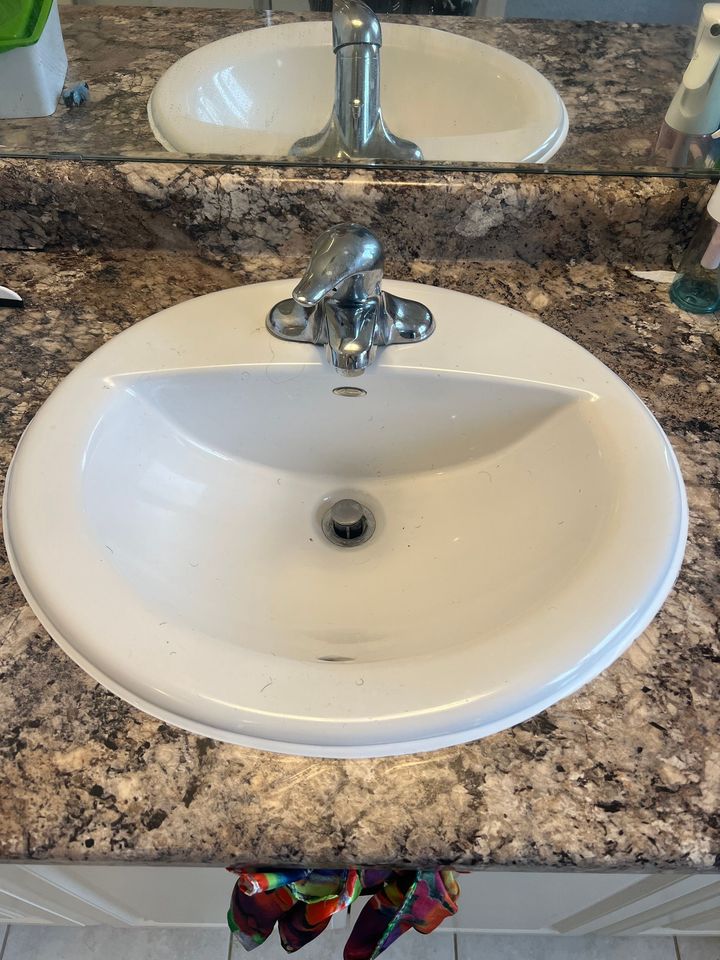 A bathroom sink with a faucet and a mirror.