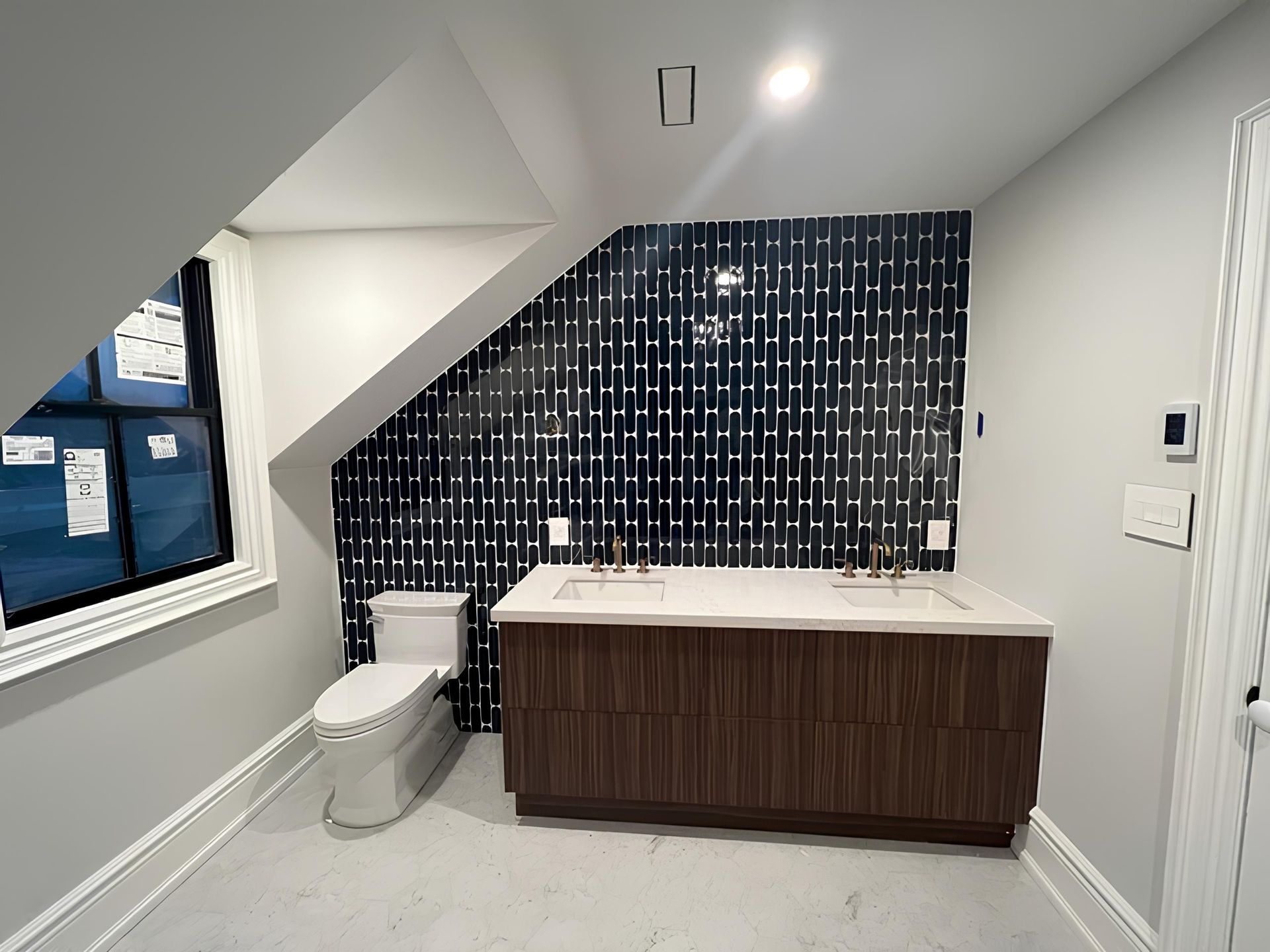 A bathroom with a toilet a sink and a window