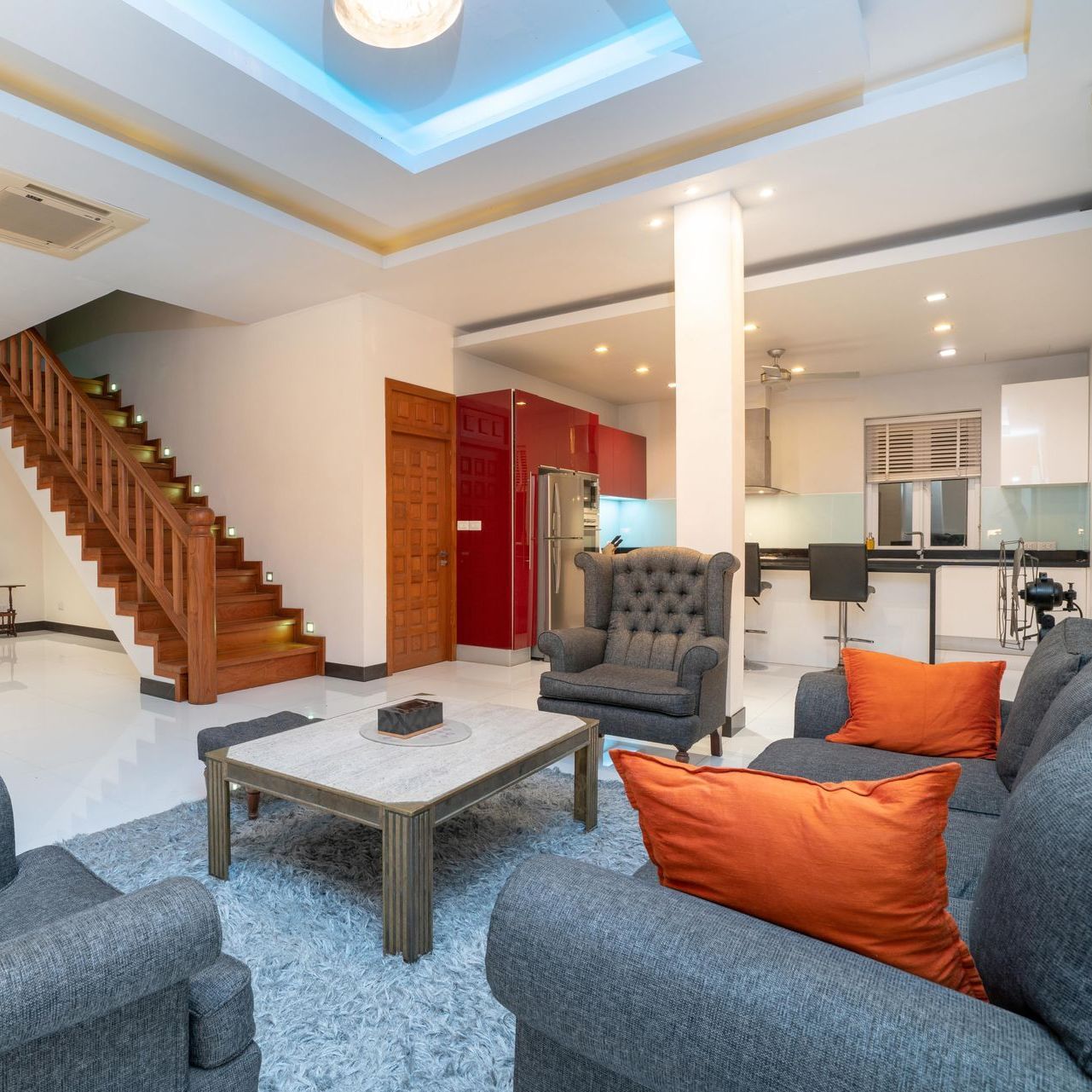 A living room with a couch , chair , coffee table and stairs