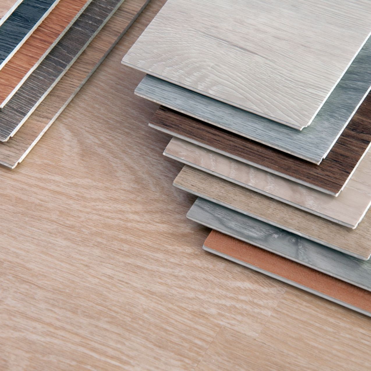 A stack of wooden tiles of different colors on a wooden floor.