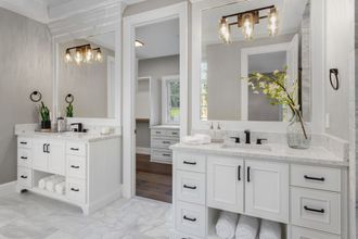 A bathroom with two sinks and two mirrors.