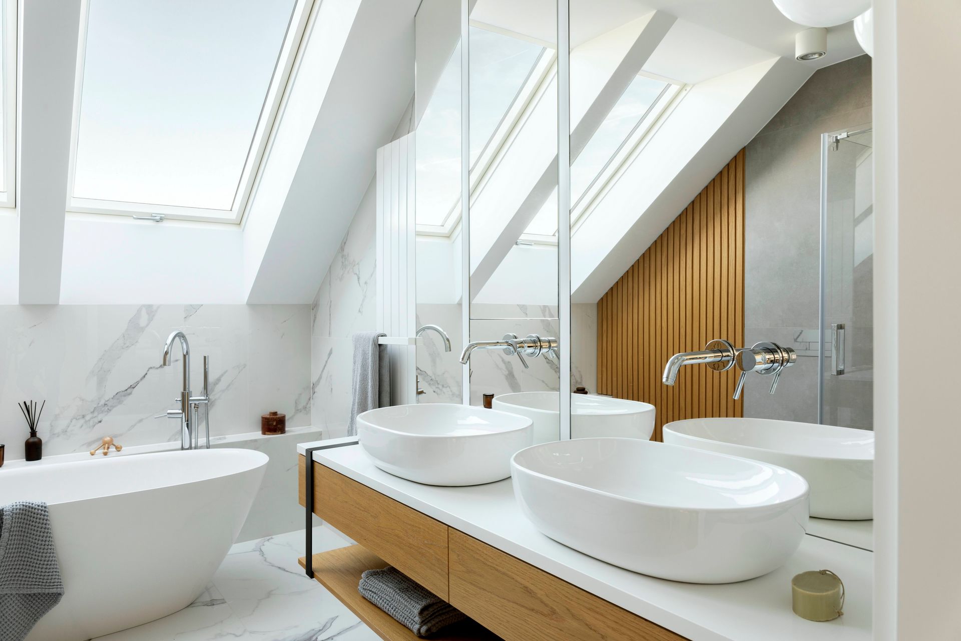 A bathroom with two sinks , a bathtub and a skylight.
