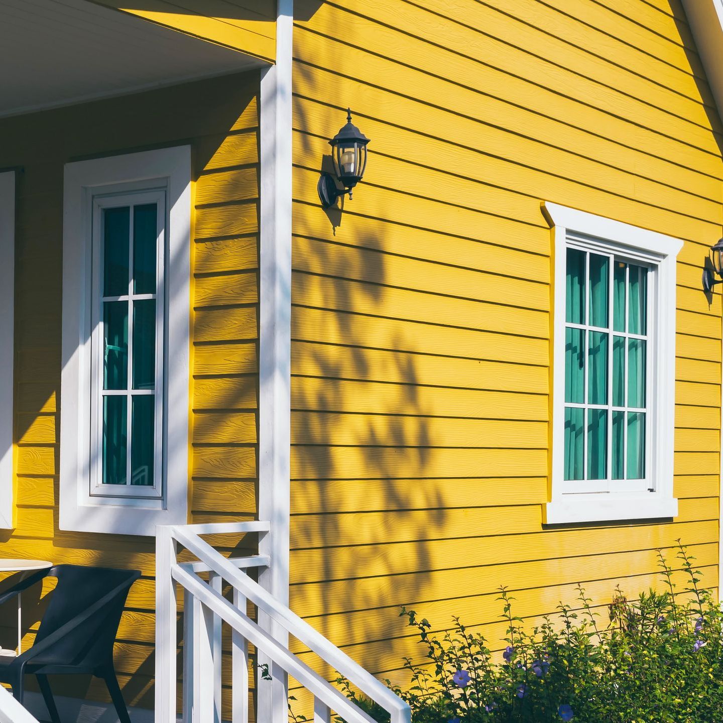 A yellow house with white trim and windows