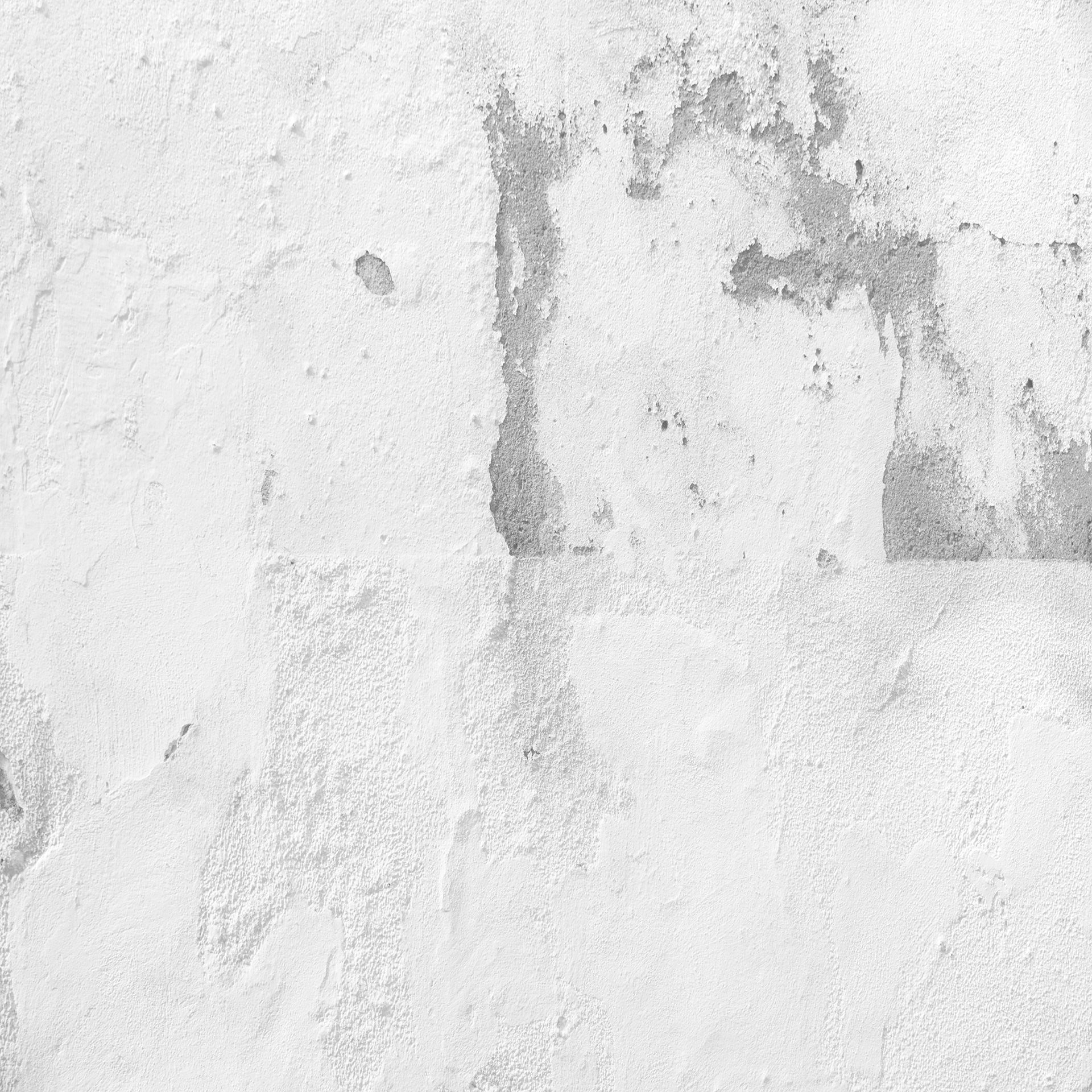A close up of a white wall with a gray stain on it.