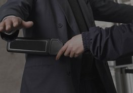 Person inspecting a handheld metal detector during a security check
