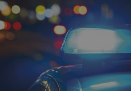 Blurred police car with flashing blue lights at night on a city street