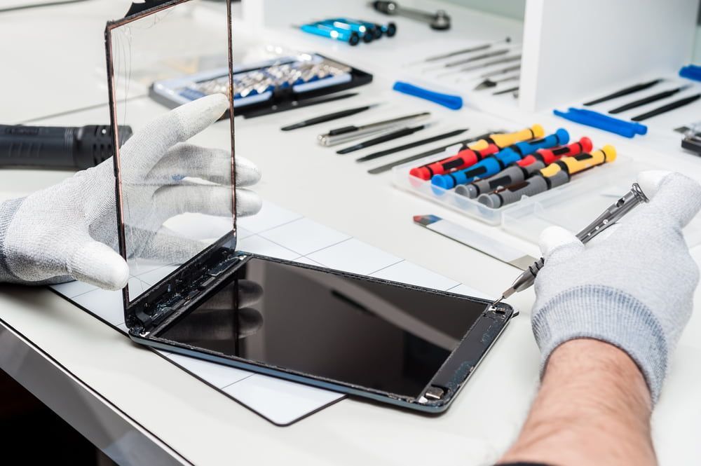 Hands Wearing White Gloves Repairing a Tablet Screen — Flexicoms Communications in Tully, QLD