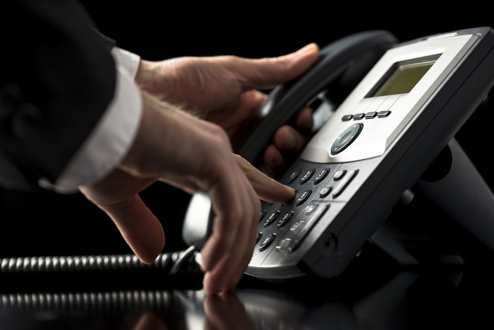Person's Hands Dialing on a Silver and Black Office Telephone — Flexicoms Communications in Innisfail, QLD 