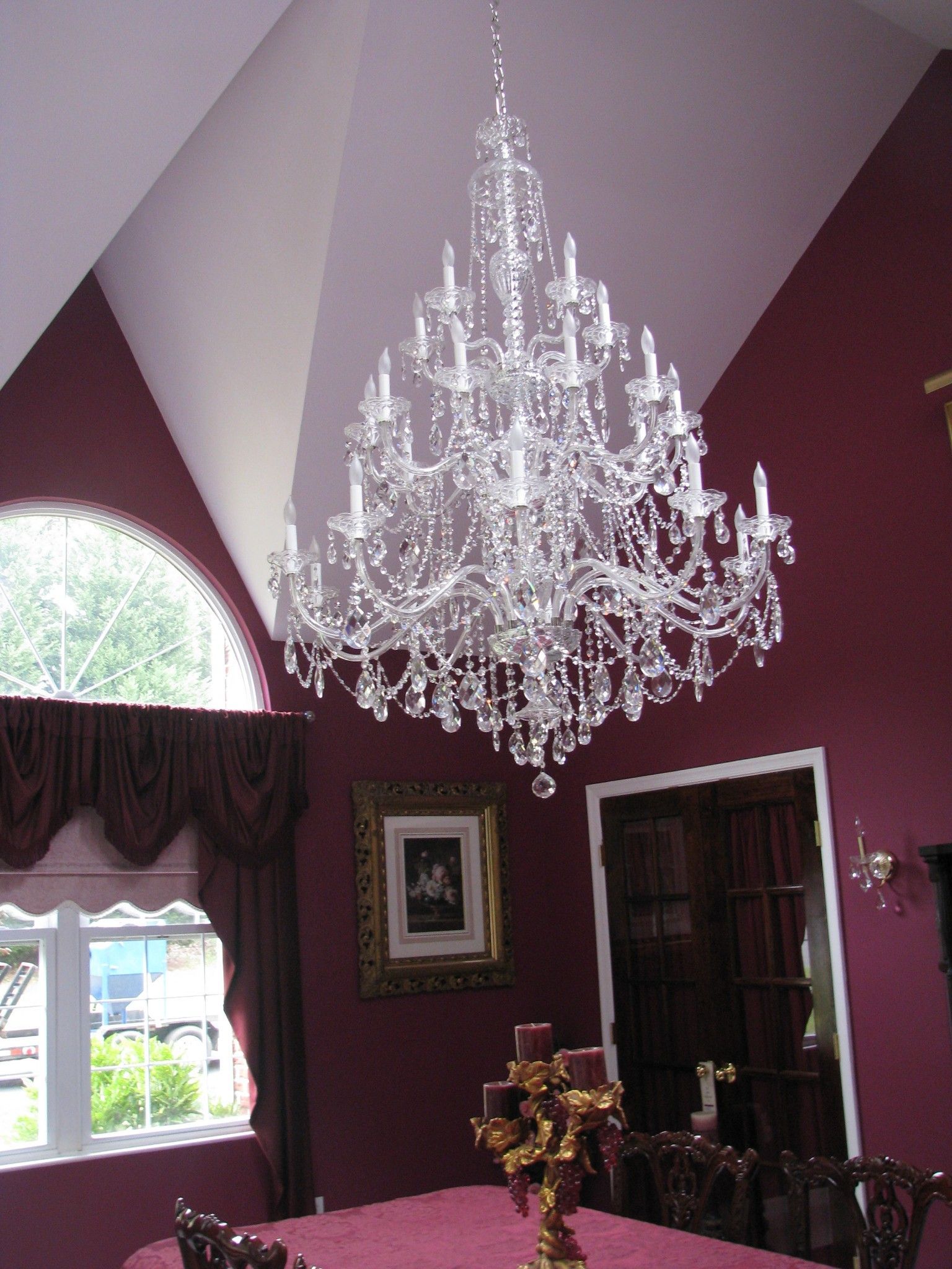 A dining room with a large chandelier hanging from the ceiling