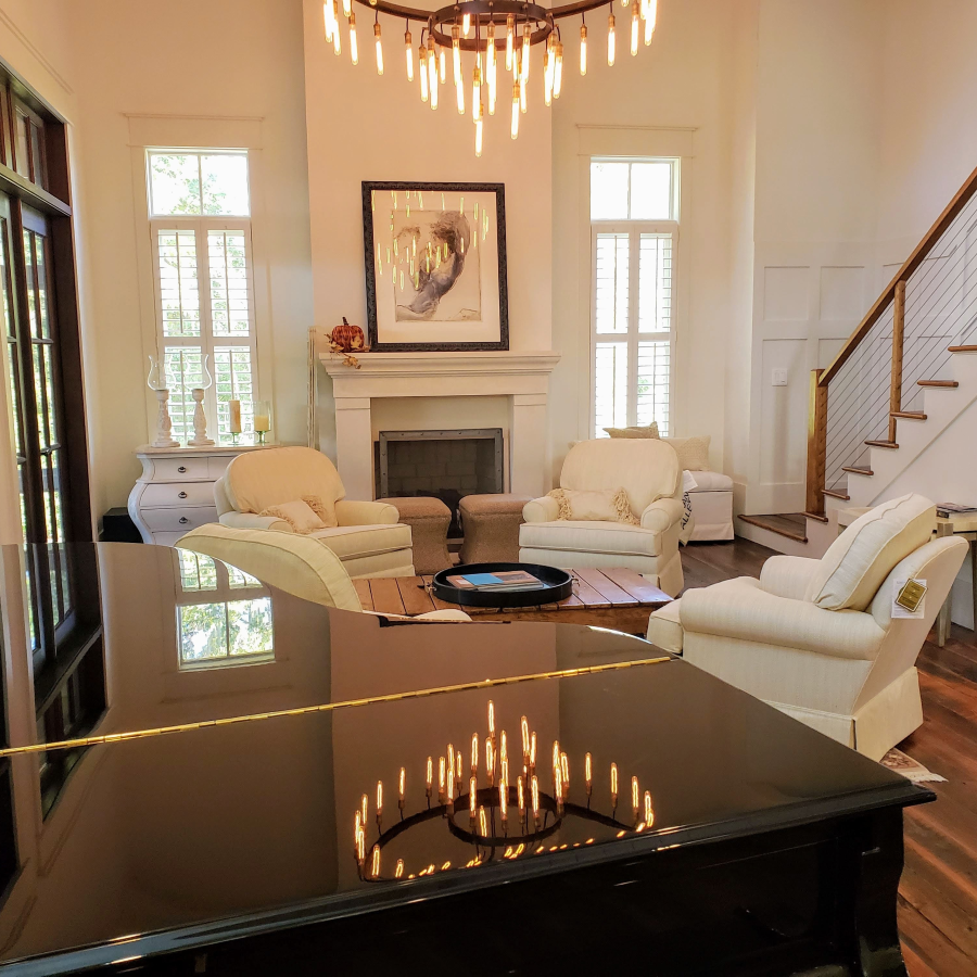A living room with a piano and chairs and a fireplace A living room with a piano and chairs and a fireplace